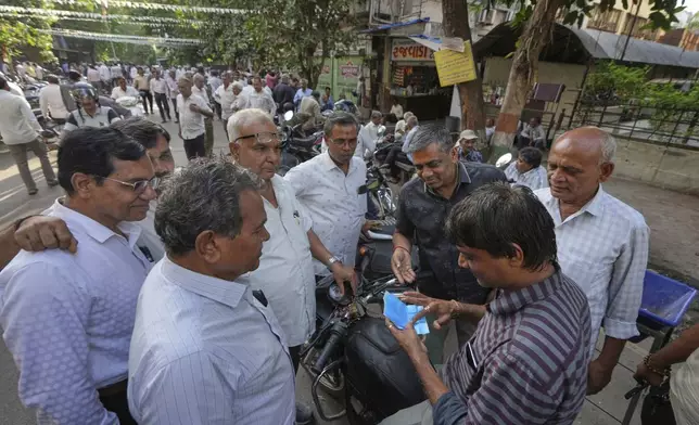 A trader inspects diamonds on a market street in Surat, India, on April 14, 2025. (AP Photo/Ajit Solanki)