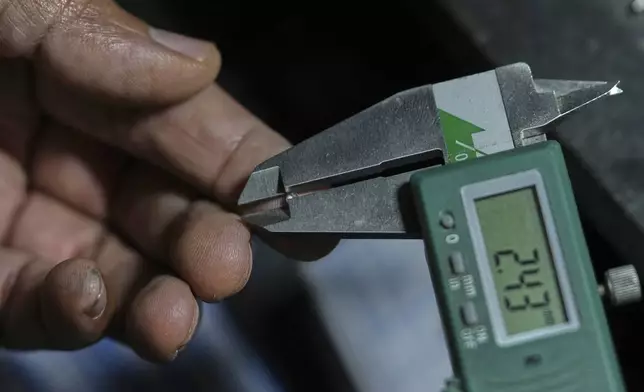 A diamond trader measures a diamond using a vernier caliper in Surat, India, on April 14, 2025. (AP Photo/Ajit Solanki)
