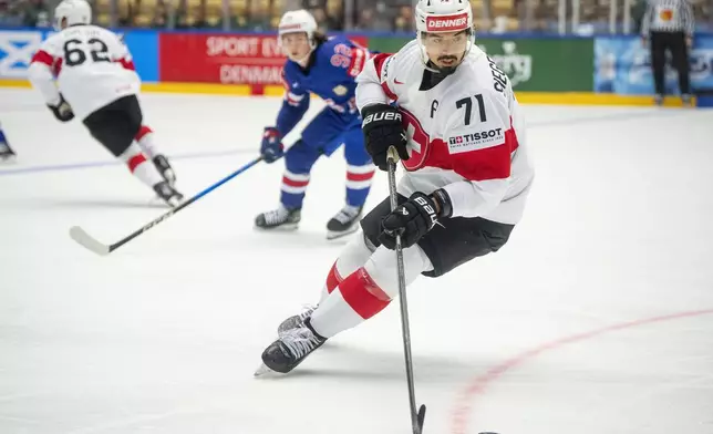 Switzerland Jonas Siegenthaler, right, challenges U.S. Logan Cooley during the IIHF Ice Hockey World Championship group B match between the U.S. and Switzerland in Herning, Denmark, Monday, May 12, 2025. (Bo Amstrup/Ritzau Scanpix via AP)