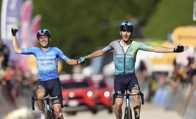 Winner of the stage Italy's Christian Scaroni of Xds Astana Team, right, and teammate Italy's Lorenzo Fortunato celebrate after crossing together the finish line during the stage 16 of the Giro d'Italia from Piazzola sul Brenta to San Valentino, Italy, Tuesday, May 27, 2025. (Massimo Paolone/LaPresse via AP)