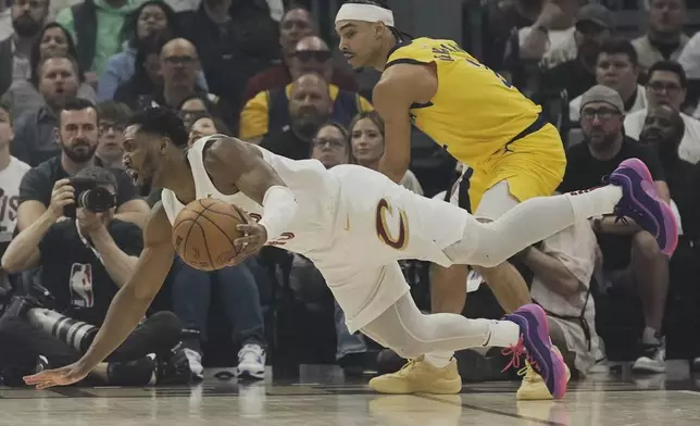 Cleveland Cavaliers guard Donovan Mitchell, left, falls after being fouled by Indiana Pacers guard Andrew Nembhard, right, in the first half during Game 2 in the Eastern Conference semifinals of the NBA basketball playoffs Tuesday, May 6, 2025, in Cleveland. (AP Photo/Sue Ogrocki)