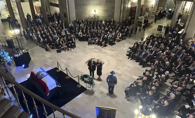 Missouri Gov. Mike Kehoe and first lady Claudia Kehoe pay their respects at a memorial service for former Missouri Gov. and U.S. Sen. Christopher Kit Bond at the state Capitol on Tuesday, May 20, 2025, in Jefferson City, Mo. (AP Photo/David A. Lieb)