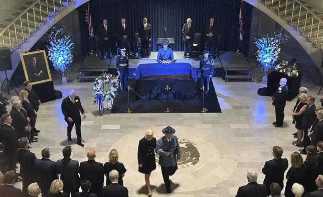 Linda Bond walks out of the Missouri Capitol Rotunda with an official escort after the memorial service for her late husband, former Missouri Gov. and U.S. Sen. Christopher Kit Bond on Tuesday, May 20, 2025, in Jefferson City, Mo. (AP Photo/David A. Lieb)