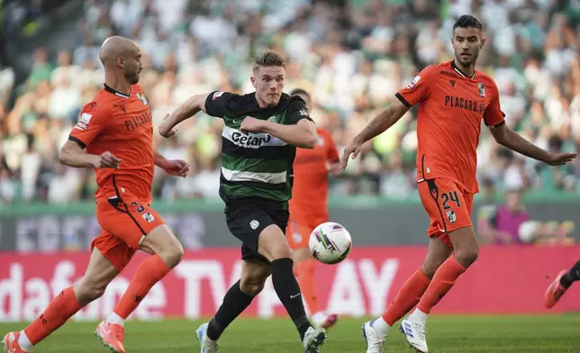 Sporting's Viktor Gyokeres, center, eyes the ball during the Portuguese league last round soccer match between Sporting CP and Vitoria SC at the Alvalade stadium in Lisbon, Saturday, May 17, 2025. (AP Photo/Ana Brigida)