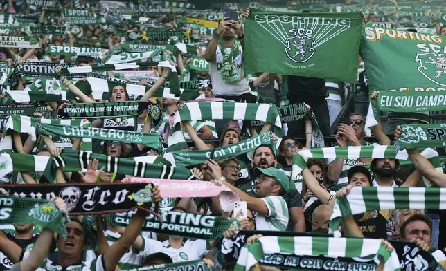 Sporting fans hold up their scarves during the Portuguese league last round soccer match between Sporting CP and Vitoria SC at the Alvalade stadium in Lisbon, Saturday, May 17, 2025. (AP Photo/Ana Brigida)