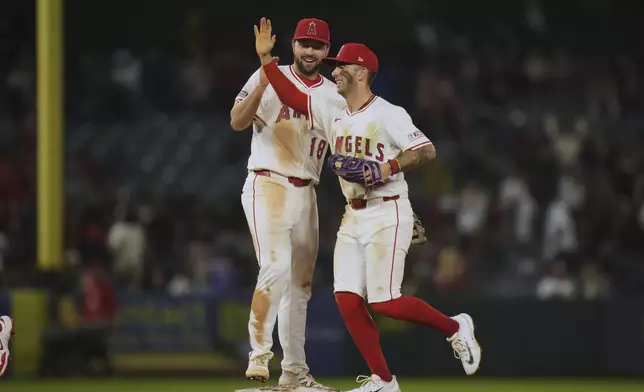 Los Angeles Angels' Nolan Schanuel (18) and Zach Neto (9) celebrate the team's 5-2 win in a baseball game against the Detroit Tigers Saturday, May 3, 2025, in Anaheim, Calif. (AP Photo/Jae C. Hong)