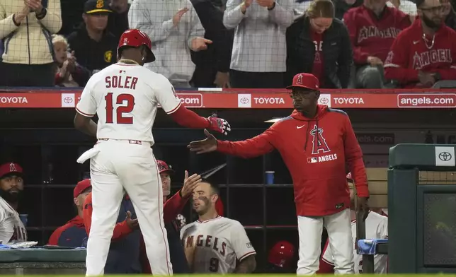 Los Angeles Angels' Jorge Soler (12) is greeted by manager manager Ron Washington after scoring on a single by Luis Rengifo during the sixth inning of a baseball game against the Detroit Tigers Saturday, May 3, 2025, in Anaheim, Calif. (AP Photo/Jae C. Hong)