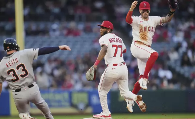 Los Angeles Angels shortstop Zach Neto (9) leaps as second baseman Tim Anderson (77) forces out Detroit Tigers' Colt Keith (33) during the second inning of a baseball game Saturday, May 3, 2025, in Anaheim, Calif. (AP Photo/Jae C. Hong)