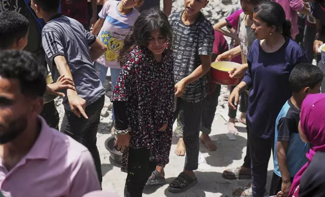 Palestinians line up for donated food at a community kitchen in Jabalia, in the northern Gaza Strip, on Monday, May 19, 2025. (AP Photo/Jehad Alshrafi)