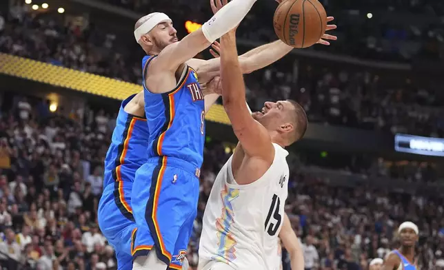 Oklahoma City Thunder guard Alex Caruso, left, blocks a shto by Denver Nuggets center Nikola Jokic in the second half of Game 6 in the Western Conference semifinals of the NBA basketball playoffs Thursday, May 15, 2025, in Denver. (AP Photo/David Zalubowski)