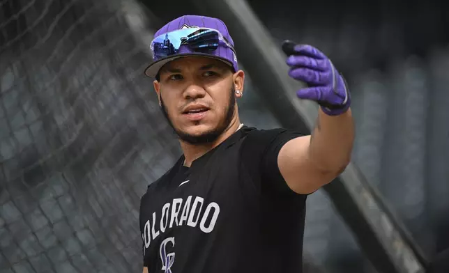 Colorado Rockies' Thairo Estrada swings his arm prior to a baseball game against the Philadelphia Phillies, Wednesday, May 21, 2025, in Denver. (AP Photo/Geneva Heffernan)