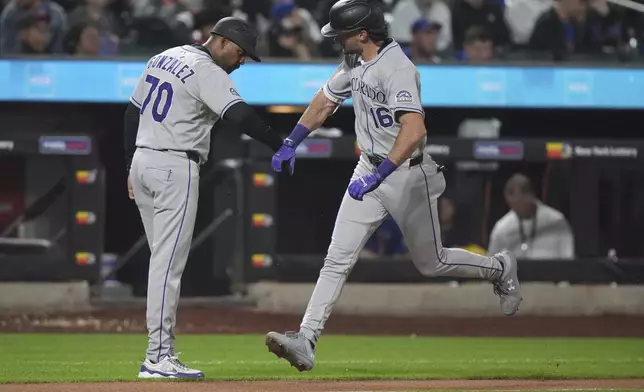 Third base coach Andy González, left, celebrates with Sam Hilliard (16) as he runs the bases after hitting a home run during the seventh inning of a baseball game against the New York Mets Friday, May 30, 2025, in New York. (AP Photo/Frank Franklin II)