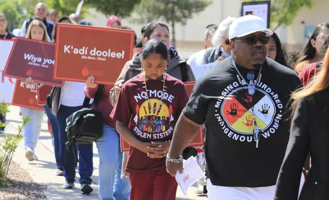 Tize W. Clark, right and his son, Zion Clark, participate in a walk to honor Native American and Indigenous relatives who have gone missing or have been killed as Missing and Murdered Indigenous Persons Awareness Day is marked in Albuquerque, New Mexico, on Monday, May 5, 2025. (AP Photo/Susan Montoya Bryan)