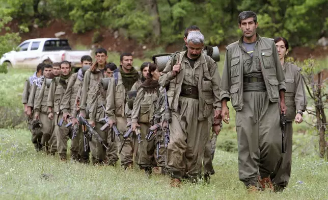 FILE - A group of armed Kurdish fighters from the Kurdistan Workers Party (PKK) enter northern Iraq in the Heror area, northeast of Dahuk, 260 miles (430 kilometers) northwest of Baghdad, Iraq, May 14, 2013. (AP Photo/Ceerwan Aziz, File)