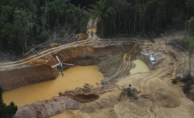 FILE - Brazil Environmental Agency helicopters fly over an illegal mining camp during an operation to try to contain the practice in Yanomami Indigenous territory, Roraima state, Brazil, Feb. 11, 2023. (AP Photo/Edmar Barros, File)