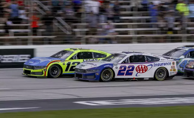 Ryan Blaney (12) and Joey Logano (22) lead the pack following a caution during a NASCAR Cup Series auto race at Texas Motor Speedway in Fort Worth, Texas, Sunday, May 4, 2025. (AP Photo/Gareth Patterson)