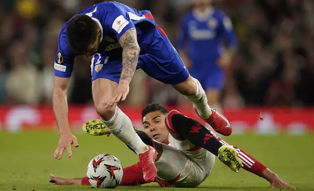 Manchester United's Casemiro, bottom, and Athletic Bilbao's Yuri Berchiche challenge for the ball during the Europa League semifinal second leg soccer match between Manchester United and Athletic Bilbao in Manchester, Britain, Thursday, May 8, 2025. (AP Photo/Dave Thompson)