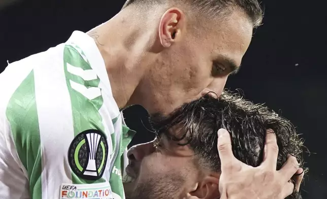 Betis' Abdessamad Ezzalzuoli celebrates with Antony, top, after scoring their second goal of the game during the UEFA Conference League second leg semifinal soccer match between Fiorentina and Real Betis at Artemio Franchi stadium in Florence, Italy, Thursday, May 8, 2025. (Marco Bucco/LaPresse via AP)