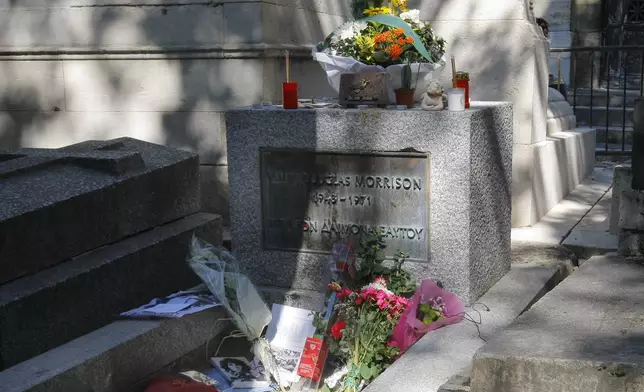 FILE - Flowers and candles adorn the grave of legendary rock front man and poet with the Doors rock band, Jim Morrison at the Pere Lachaise cemetery in Paris Monday July. 3, 2011. Morrison, the legendary singer of the rock band died in Paris on July, 2, 1971. (AP Photo/Jacques Brinon, File)