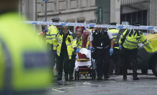 Police and emergency personnel deal with an incident near the Liver Building during the Premier League winners parade, in Liverpool, England, Monday May 26, 2025. (Owen Humphreys/PA via AP)
