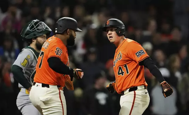 San Francisco Giants' Wilmer Flores, right, celebrates Heliot Ramos after hitting a three-run home run during the sixth inning of a baseball game against the Athletics, Friday, May 16, 2025, in San Francisco. (AP Photo/Godofredo A. Vásquez)