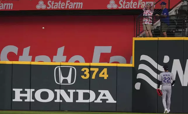 Colorado Rockies outfielder Mickey Moniak (22) looks on as Texas Rangers' Josh Jung's home run clears the wall during the first inning of a baseball game, Tuesday, May 13, 2025, in Arlington, Texas. (AP Photo/LM Otero)