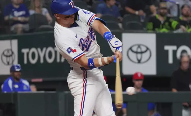 Texas Rangers' Josh Jung hits a home run during the first inning of a baseball game against the Colorado Rockies, Tuesday, May 13, 2025, in Arlington, Texas. (AP Photo/LM Otero)
