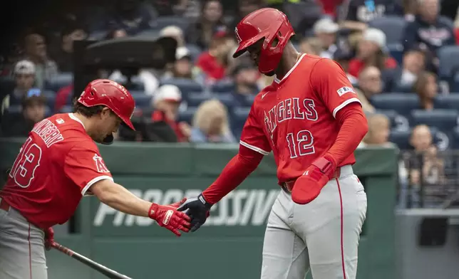Los Angeles Angels' Scott Kingery, left, congratulates Jorge Soler (12) after Soler scored on a single by Jo Adell during the second inning of a baseball game against the Cleveland Guardians, Friday, May 30, 2025, in Cleveland. (AP Photo/Phil Long)