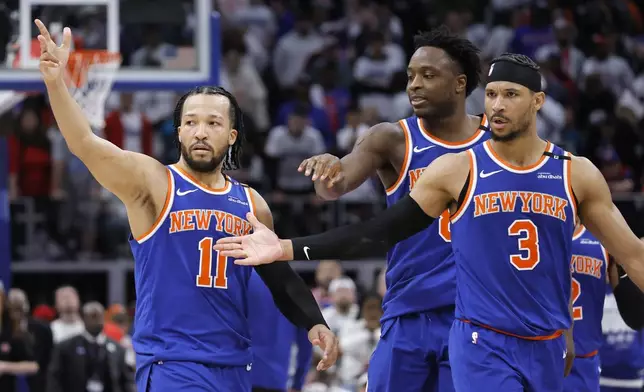 New York Knicks guard Jalen Brunson (11) celebrates with forward OG Anunoby, center, and guard Josh Hart (3) after scoring the winning basket in a win over the Detroit Pistons in Game 6 of an NBA basketball first-round playoff series Thursday, May 1, 2025, in Detroit. (AP Photo/Duane Burleson)
