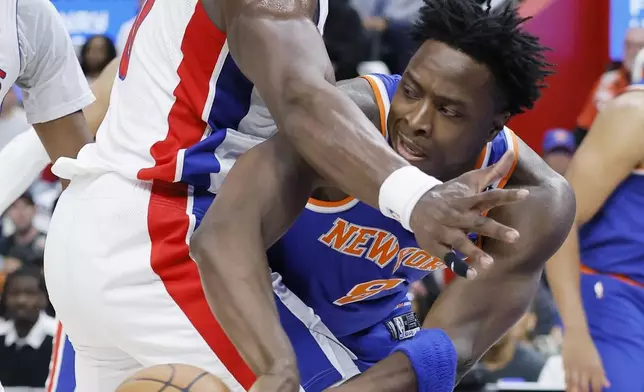 New York Knicks forward OG Anunoby (8) passes the ball against Detroit Pistons center Jalen Duren, left, during the first half of Game 6 of an NBA basketball first-round playoff series Thursday, May 1, 2025, in Detroit. (AP Photo/Duane Burleson)