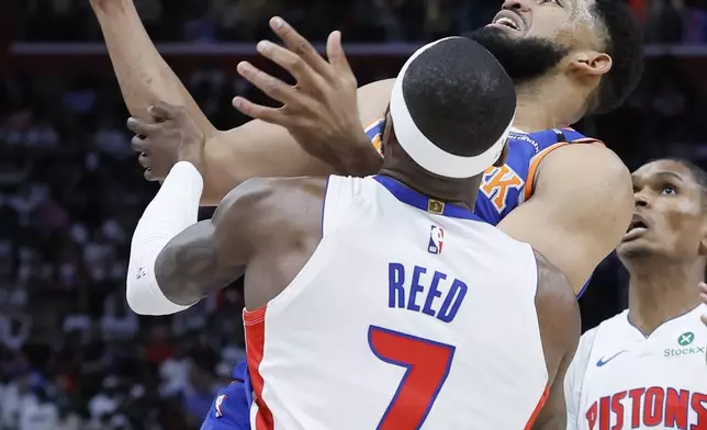 New York Knicks center Karl-Anthony Towns, top, has the ball knocked away by Detroit Pistons forward Paul Reed (7) during the first half of Game 6 of an NBA basketball first-round playoff series Thursday, May 1, 2025, in Detroit. (AP Photo/Duane Burleson)