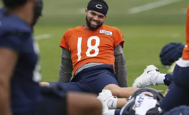 Chicago Bears quarterback Caleb Williams (18) smiles as he warms up during NFL football practice in Lake Forest, Ill., Wednesday, May 28, 2025. (AP Photo/Nam Y. Huh)