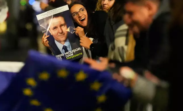 Supporters of Presidential candidate Nicusor Dan celebrate on the street after polls closed for the second round of the country's presidential election redo in Bucharest, Romania, Sunday, May 18, 2025. (AP Photo/Vadim Ghirda)