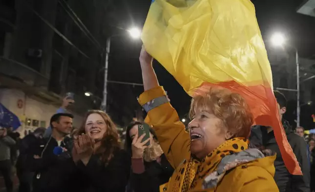 Supporters of presidential candidate Nicusor Dan celebrate on the street after polls closed for the second round of the country's presidential election redo in Bucharest, Romania, early Monday, May 19, 2025. (AP Photo/Andreea Alexandru)