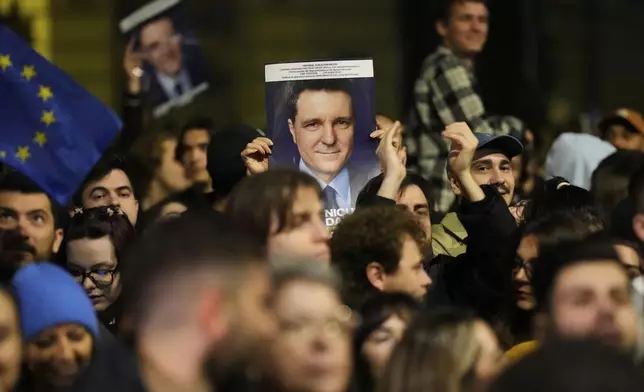 Supporters of presidential candidate Nicusor Dan celebrate on the street after polls closed for the second round of the country's presidential election redo in Bucharest, Romania, early Monday, May 19, 2025.(AP Photo/Vadim Ghirda)