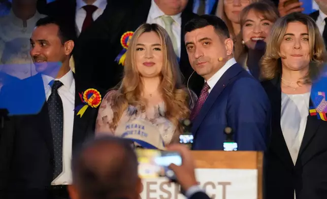 Presidential candidate George Simion, front right, poses with his wife Ilinca before a press conference after polls closed for the second round of the country's presidential election redo in Bucharest, Romania, Sunday, May 18, 2025. (AP Photo/Vadim Ghirda)