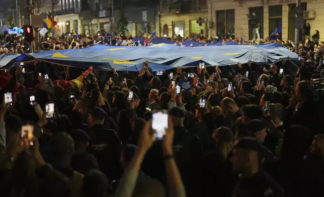 Supporters of Presidential candidate Nicusor Dan celebrate on the street after polls closed for the second round of the country's presidential election redo in Bucharest, Romania, Sunday, May 18, 2025. (AP Photo/Andreea Alexandru)