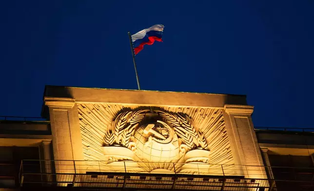 FILE - A Russian state flag waves on top of a hummer and sickle at the State Duma, lower parliament chamber, headquarters in Moscow, Russia, Sunday, March 3, 2019. (AP Photo/Alexander Zemlianichenko, File)