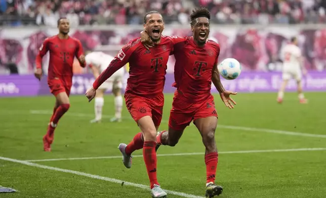 Bayern's Leroy Sane, left, celebrates with Kingsley Coman, after scoring his side's third goal during the German Bundesliga soccer match between RB Leipzig and FC Bayern Munich at the Red Bull Arena in Leipzig, Germany, Saturday, May 3, 2025. (AP Photo/Matthias Schrader)