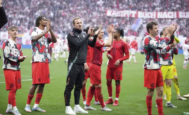 Bayern's Harry Kane, centre, applauds supporters at the end of the German Bundesliga soccer match between RB Leipzig and FC Bayern Munich at the Red Bull Arena in Leipzig, Germany, Saturday, May 3, 2025. (AP Photo/Ebrahim Noroozi)