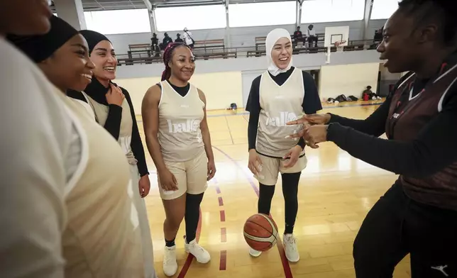 Players, some wearing headscarves, huddle during competition in Aubervilliers near Paris, Sunday, April 27, 2025. (AP Photo/Thomas Padilla)