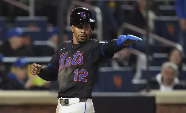 New York Mets' Francisco Lindor (12) gestures to Juan Soto as he scores on a single by Soto during the eighth inning of a baseball game against the Chicago Cubs Friday, May 9, 2025, in New York. (AP Photo/Frank Franklin II)