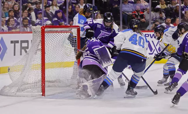 Toronto Sceptres defender Kali Flanagan, second from right, scores past Minnesota Frost goaltender Maddie Rooney, front left, in the second period of a PWHL hockey playoff game Sunday, May 11, 2025, in St. Paul, Minn. (AP Photo/Bruce Kluckhohn)