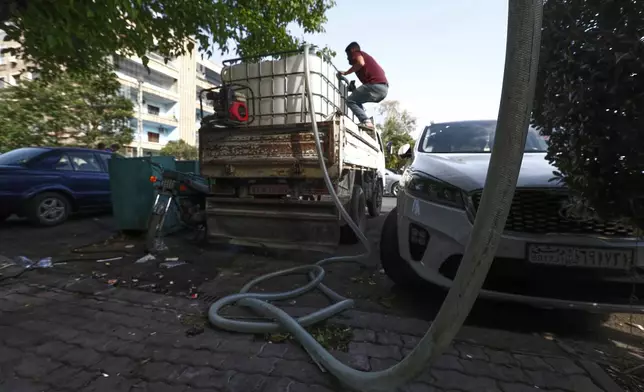 A worker supplies water from a tank to houses in Damascus, Sunday, May 11, 2025.(AP Photo/Omar Sanadiki)