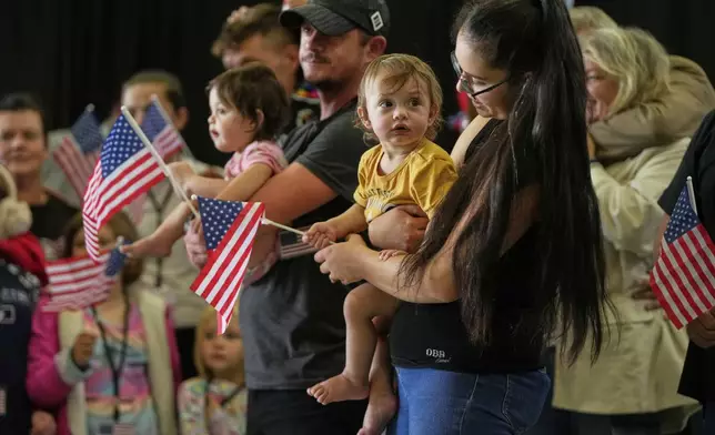 Afrikaner refugees from South Africa holding American flags arrive, Monday, May 12, 2025, at Dulles International Airport in Dulles, Va. (AP Photo/Julia Demaree Nikhinson)