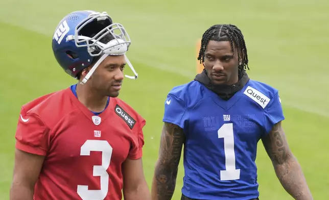 New York Giants' Malik Nabers, right, talks with quarterback Russell Wilson as they walk off the field after NFL football practice in East Rutherford, N.J., Wednesday, May 28, 2025. (AP Photo/Seth Wenig)