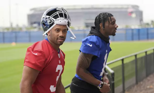 New York Giants' quarterback Russell Wilson, left, and Malik Nabers talk as they walk off the field after an NFL football practice in East Rutherford, N.J., Wednesday, May 28, 2025. (AP Photo/Seth Wenig)