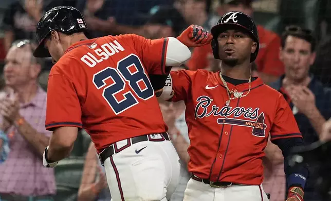 Atlanta Braves' Matt Olson (28) celebrates his solo homer with Ozzie Albies (1) in the seventh inning of a baseball game against the Los Angeles Dodgers, Friday, May 2, 2025, in Atlanta. (AP Photo/Mike Stewart)