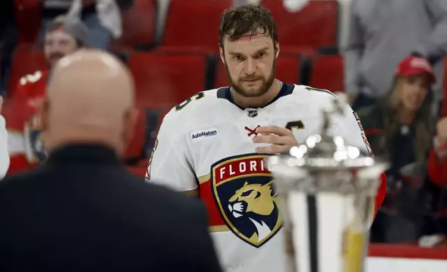 Florida Panthers' Aleksander Barkov (16) skates over to accept the Prince of Wales Trophy following Game 5 of the NHL hockey Stanley Cup Eastern Conference finals against the Carolina Hurricanes in Raleigh, N.C., Wednesday, May 28, 2025. (AP Photo/Karl DeBlaker)