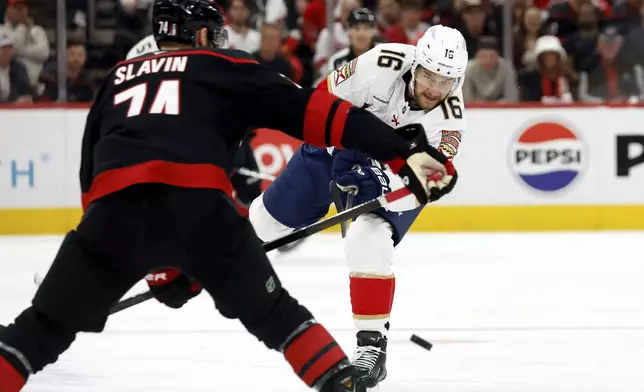Florida Panthers' Aleksander Barkov (16) clears the puck past Carolina Hurricanes' Jaccob Slavin (74) during the first period of Game 5 of the NHL hockey Stanley Cup Eastern Conference finals in Raleigh, N.C., Wednesday, May 28, 2025. (AP Photo/Karl DeBlaker)